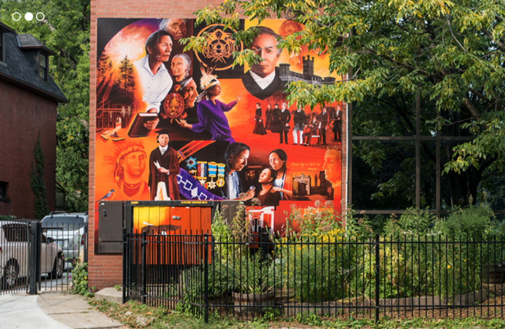 A photograph of Miziwe Biik's building and an orange mural